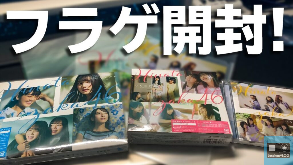 日本語では「フラゲ開く！」と書かれています。日向坂46の数枚のアルバムがテーブルの上に並べられています。アルバムのジャケットには、グループのメンバーがさまざまなポーズをとっています。.